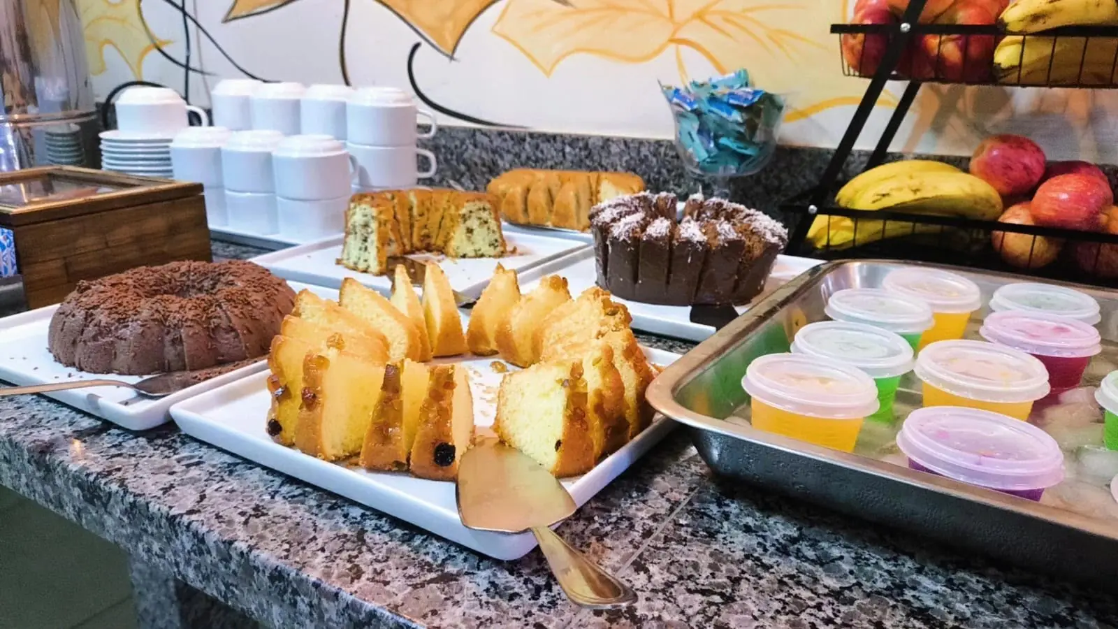 Buffet do café da manhã com bolos, frutas e sucos