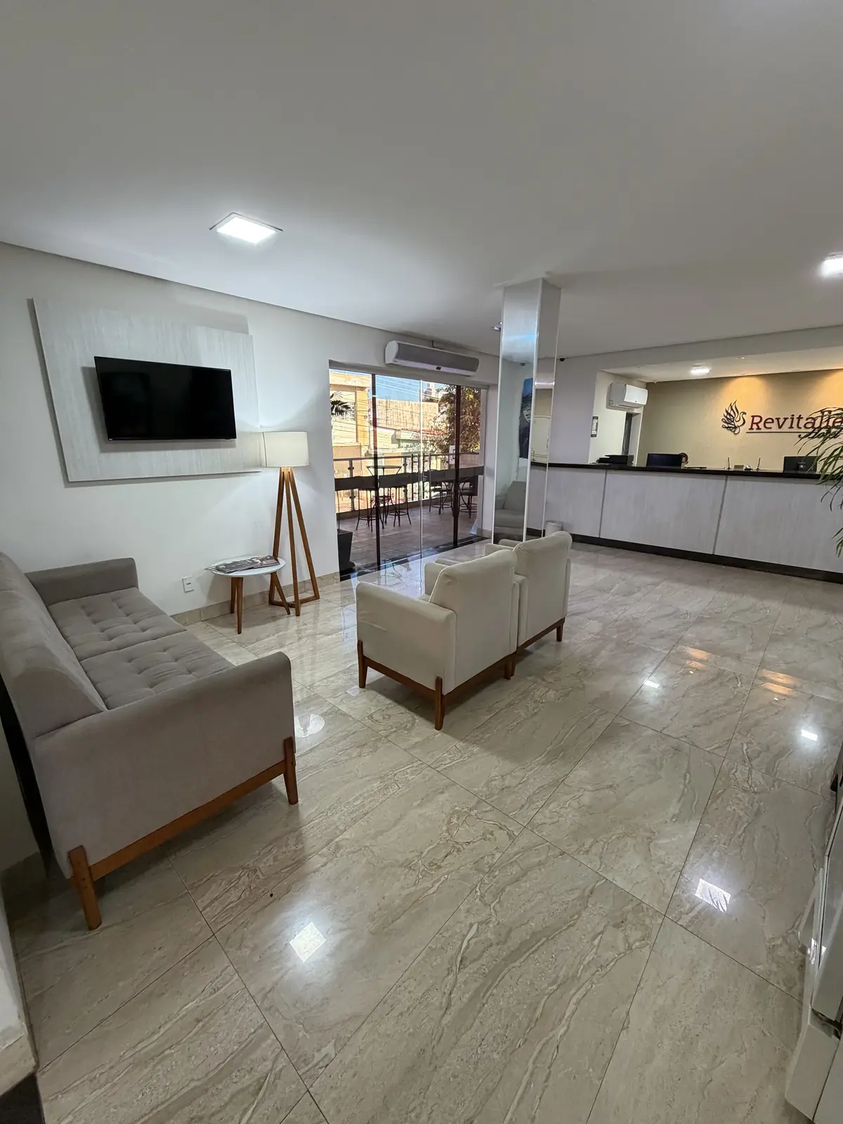 Lounge do Hotel Revitalle com poltronas e TV