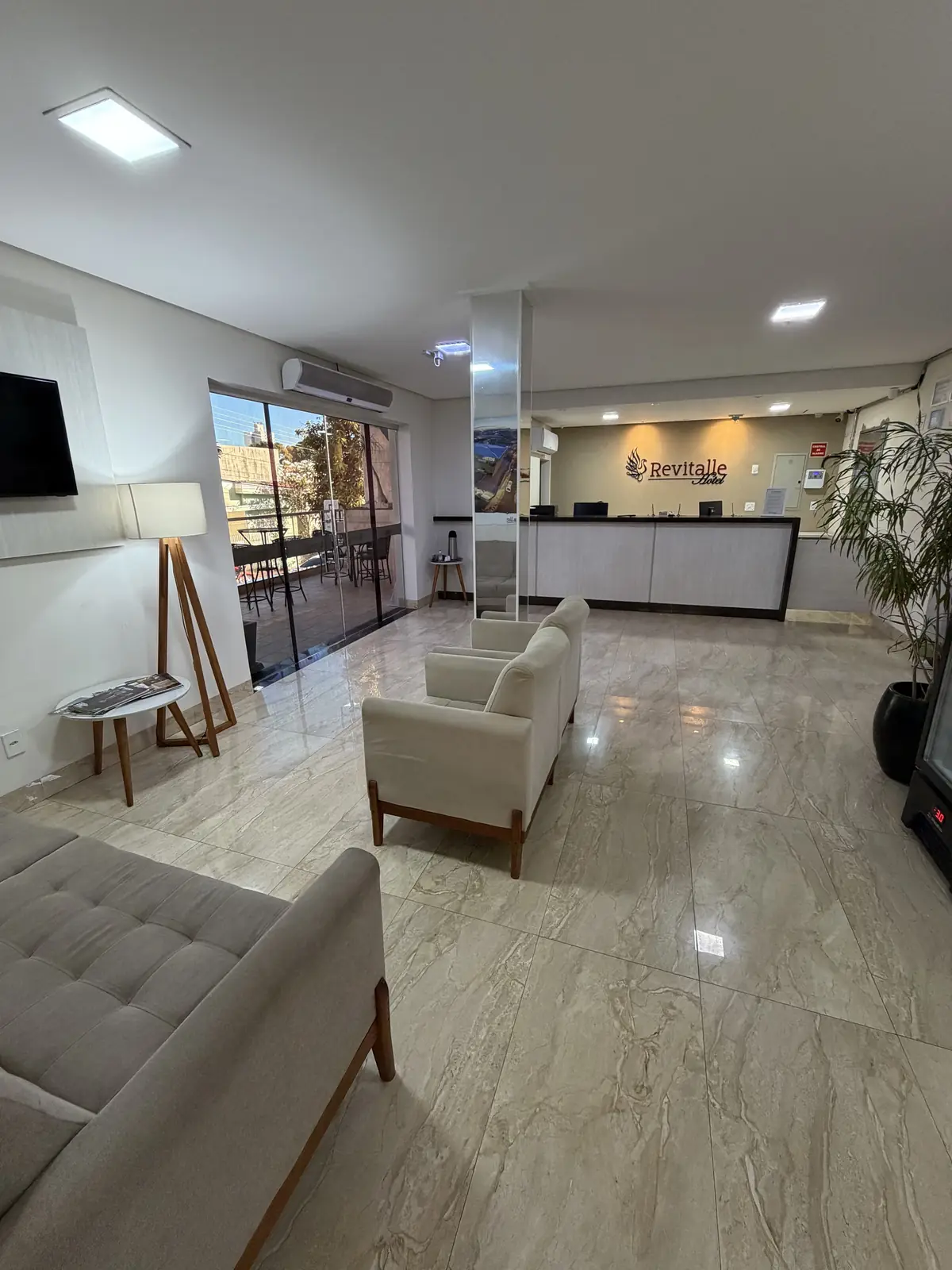 Recepção do Hotel Revitalle, com sofás e o logo na parede